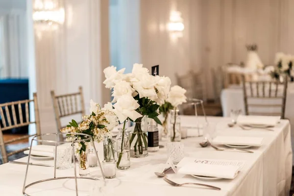 stock image A table decorated with beautiful white flowers and candles on a wedding party