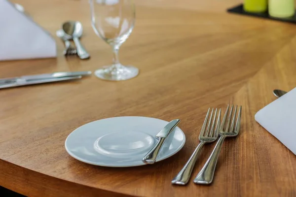 プレート フォーク スプーン カトラリー レストランの木製テーブルの上のダイニングテーブル クローズアップショット — ストック写真