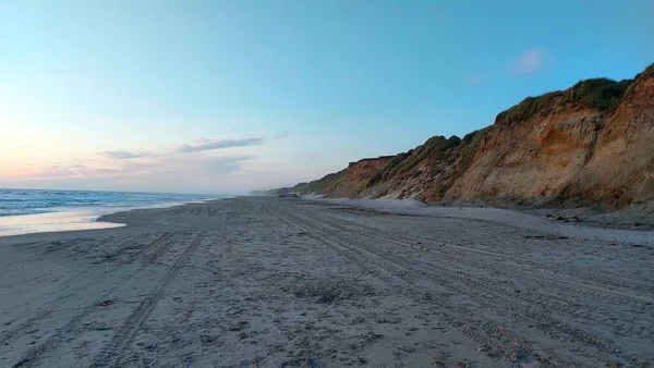 壁紙に最適な夕日で砂浜の上に海の波が飛び込みます — ストック写真