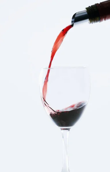 Uma Garrafa Vinho Tinto Derramando Copo Vinho Com Fundo Branco — Fotografia de Stock