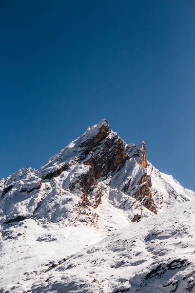 Vertikal Bild Snöig Stenig Bergstopp Blå Molnfri Himmel Solig Dag — Stockfoto