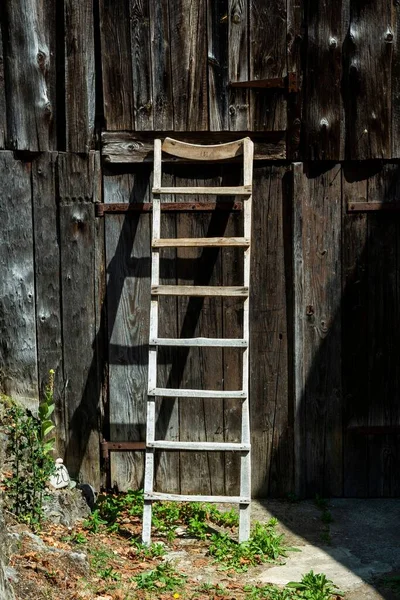 Close Vertical Uma Escada Madeira Apoiada Uma Cerca Madeira Escura — Fotografia de Stock