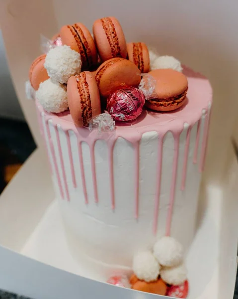 マカロンで装飾された背の高い白とピンクのケーキの垂直ショット — ストック写真