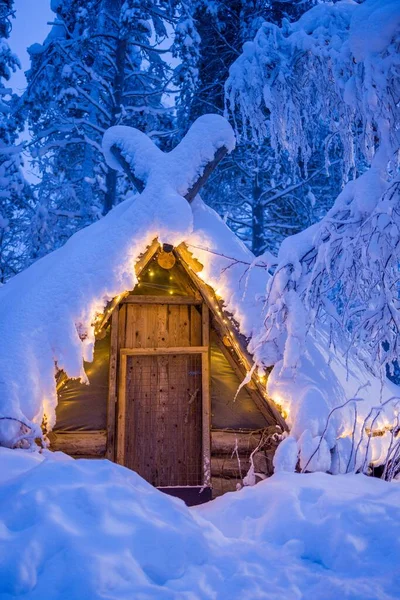 在北极圈雪地上有灯光的圆木小屋的垂直照片 芬兰拉普兰 — 图库照片