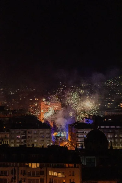 在黑暗的背景和城市景观下 高耸的壮观的五彩缤纷的新年焰火 — 图库照片