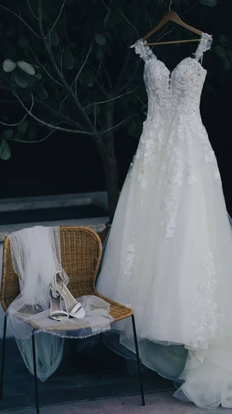 Uno Sparo Verticale Abito Sposa Bianco Una Gruccia Vicino Scarpe — Foto Stock