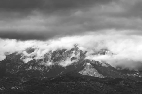 Uma Escala Cinza Pico Montanha Coberto Nevoeiro Com Céu Dramático — Fotografia de Stock