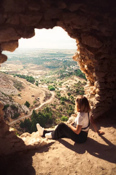 Вертикальний Знімок Молодої Дівчини Сидить Краю Печери Дивлячись Сільські Дороги — стокове фото