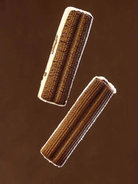 Koyu Kahverengi Arka Planda Izole Edilmiş Lezzetli Yüzen Bisküviler Kremalı — Stok fotoğraf