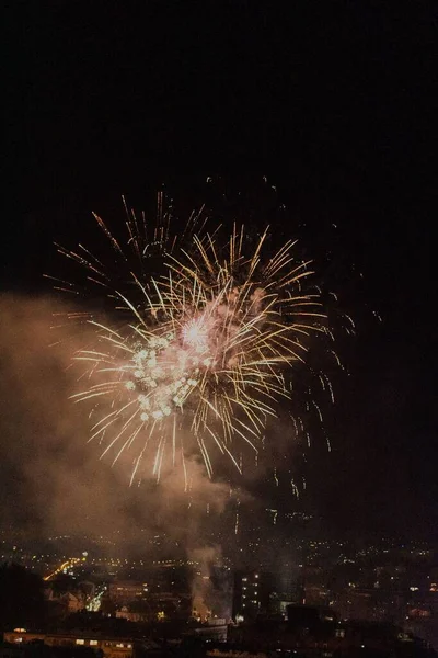 暗い背景や街並みを背景にしたカラフルな新年の花火 — ストック写真