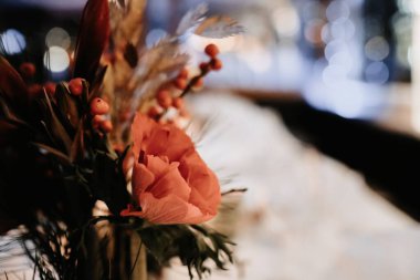 Bulanık bir arkaplanda Noel süslemesi için masanın üzerine yakın plan bir çiçek resmi.