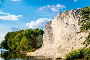 Yeşil ağaçlar ve sahilde büyük bir uçurum güneşli bir günde mavi gökyüzüne karşı