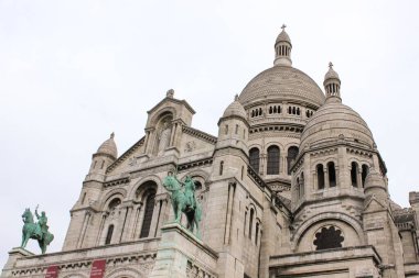 Sacre-Coeur Bazilikası 'nın Paris, Fransa' daki beyaz gökyüzüne karşı alçak açılı bir çekimi.