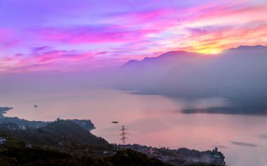 Kıyı şeridi boyunca uzanan dağların hava manzarası. Arka planda güzel bir alacakaranlık görünüyor.