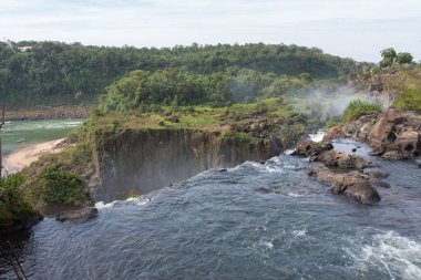 Arjantin 'de mavi gökyüzü olan ahşap ağaçlı Iguazu şelalelerinin manzarası.