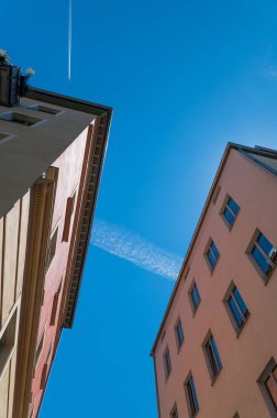 Güneşli bir günde mavi gökyüzünün altındaki pembe binaların alçak açılı görüntüsü.