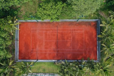 Güzel ağaçlarla çevrili bir tenis sahası manzarası.