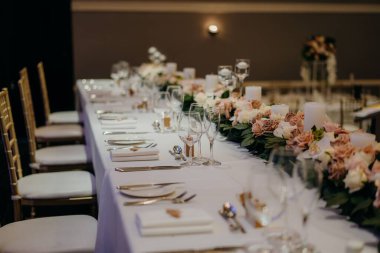 Çiçeklerle süslenmiş güzel bir düğün yerinde uzun bir masa.