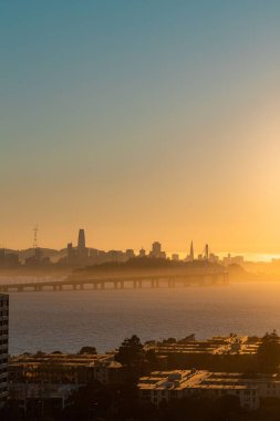 San Francisco 'nun hava manzarası. Gün batımında binalar ve suyla çevrili.