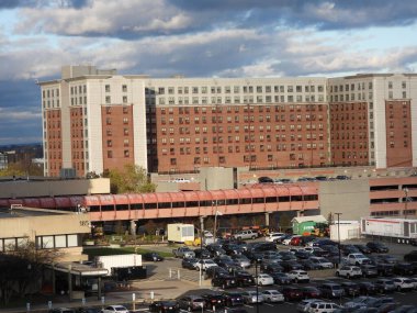 Otoparktaki binaların ve arabaların üzerinde kara bulutlar.