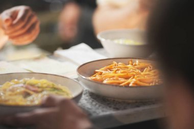 Masaya konmuş spagetti kasesi ve diğer tabaklar.