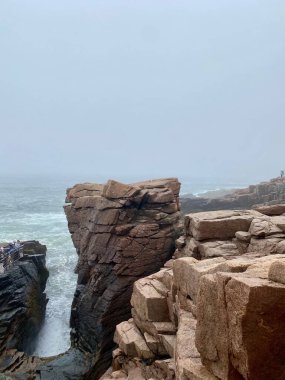 Gündüz vakti arkaplanda temiz deniz olan dev kaya oluşumlarının dikey çekimi