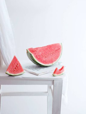 Beyaz bir zemin üzerinde beyaz bir tahta üzerinde dikey bir karpuz dilimi.