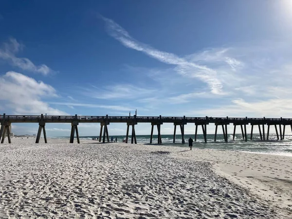 晴れた日には桟橋に向かって砂浜を歩く人の風景 — ストック写真