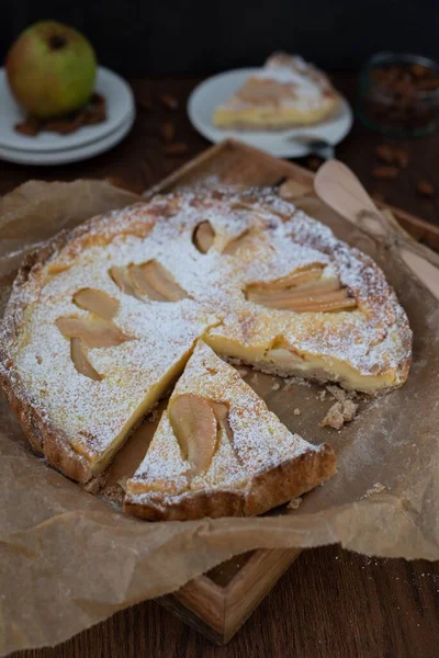A vertical shot of a delicious homemade pear pie with a slice cut out