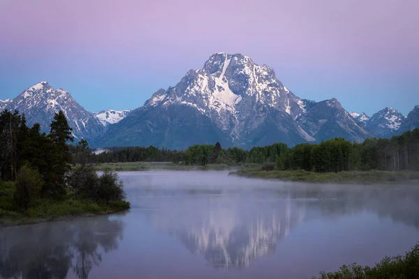 Una Escena Púrpura Puesta Sol Montañas Nevadas Reflejándose Lago Con —  Fotos de Stock