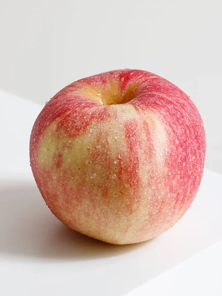 Närbild Ett Rött Äpple Hörnet Ett Vitt Bord — Stockfoto