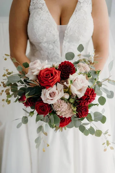 赤い白い花束を持つ白いドレスに美しい花嫁の垂直ショット — ストック写真