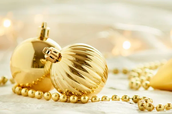 Tiro Close Ornamentos Dourados Natal Colocados Uma Superfície Branca — Fotografia de Stock