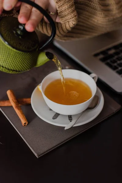 Вертикальный Снимок Женской Руки Наливающей Чай Корицей Чашку Кафе — стоковое фото
