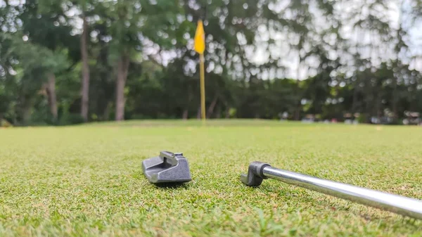 Trasig Golfputter Låg Det Gröna Fältet Mot Suddig Gul Flagga — Stockfoto