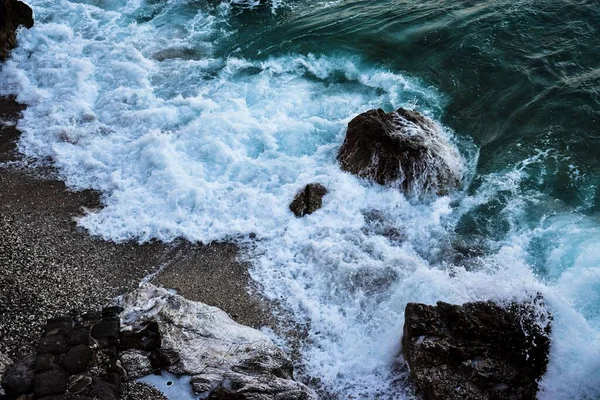 Kayalık Bir Kıyı Şeridini Kaplayan Köpüklü Deniz Dalgalarının Yakın Çekimi — Stok fotoğraf