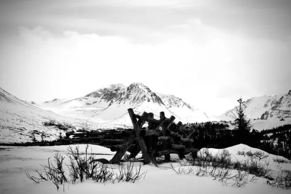 背景に山のある冬の風景の中の木製の柵のグレースケール — ストック写真