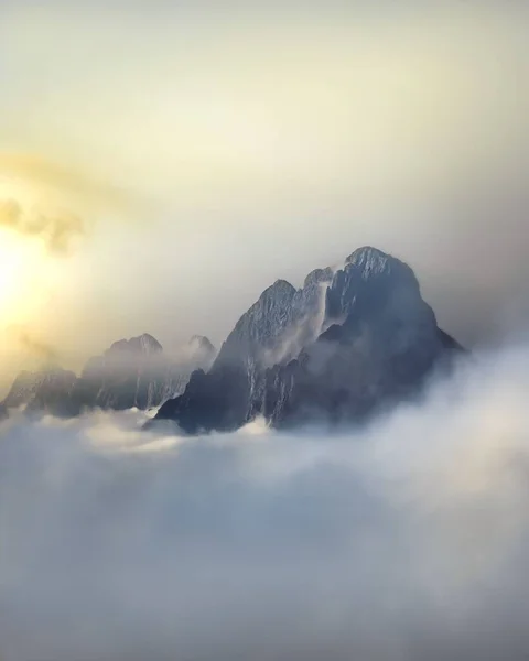 Eine Vertikale Aufnahme Der Felsigen Berggipfel Die Aus Den Wolken — Stockfoto