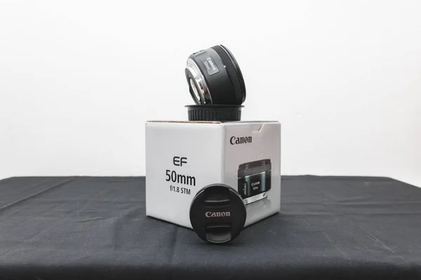 Een Canon 50Mm Stm Lens Zijn Doos Een Zwarte Tafel — Stockfoto