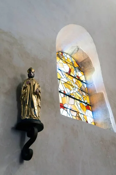 Pystysuora Kuva Uskonnollisesta Patsaasta Seinällä Lasimaalauksen Alla — kuvapankkivalokuva