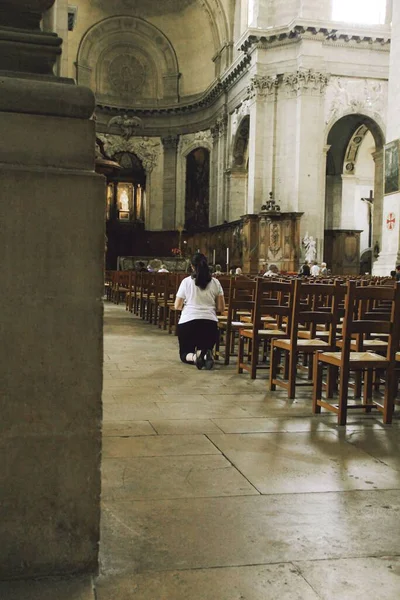 stock image A vertical shot of a woman on her knees praying inside the church