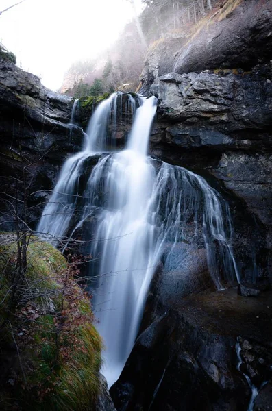 Tiro Vertical Uma Cachoeira Cercada Por Montanhas Rochosas Florestas Luz — Fotografia de Stock