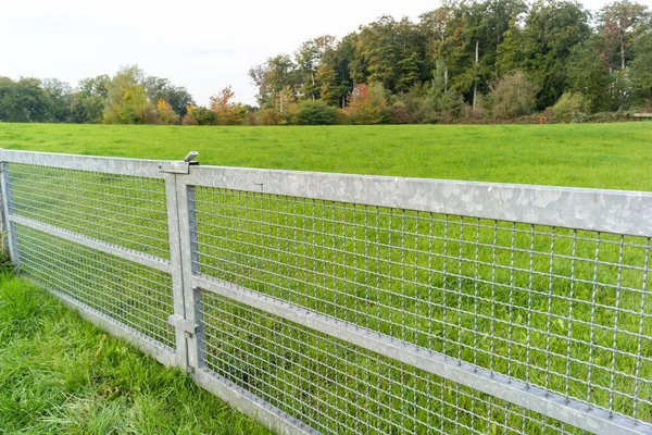 明るい緑の谷に金属製のフェンスの高角度ショット — ストック写真