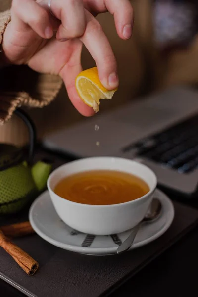 Крупный План Девушки Втискивающей Лимон Чашку Чая Баре Коричными Палочками — стоковое фото