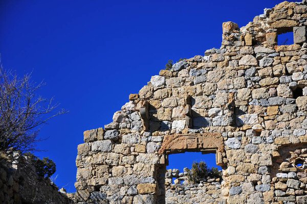 The old stone wall against the background of the blue sky. Oden Castle, Spain.