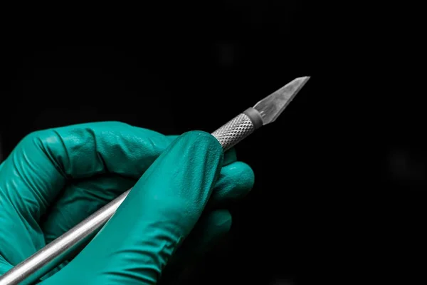 Крупный План Руки Хирурга Зеленой Пластиковой Перчатке Держащей Скальпель — стоковое фото