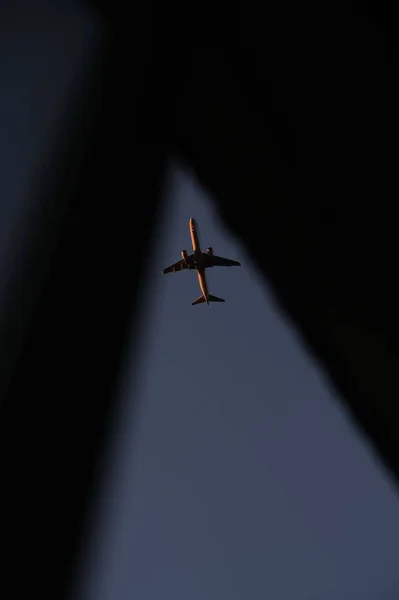 从一个小缝隙中看到商业飞机在空中飞行的垂直镜头 — 图库照片