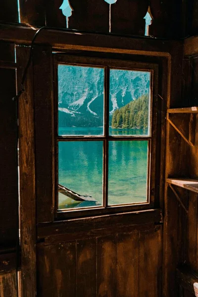 从木屋窗户后面看到的美丽的湖水和大自然的垂直照片 — 图库照片