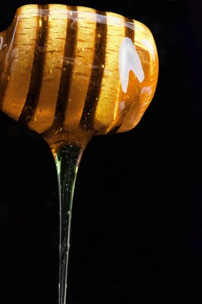 Ein Vertikaler Schuss Honig Tropft Aus Einem Hölzernen Honiglöffel Auf — Stockfoto