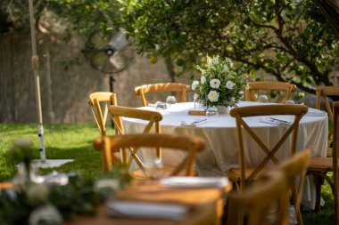 Güneşli bir günde sokakta küçük çiçeklerle süslenmiş ahşap bir festival masası.